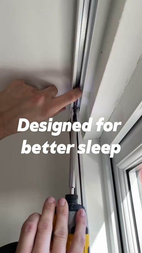 Blockout blind with side channels fitted to a Sydney bedroom window, fabric running inside the track